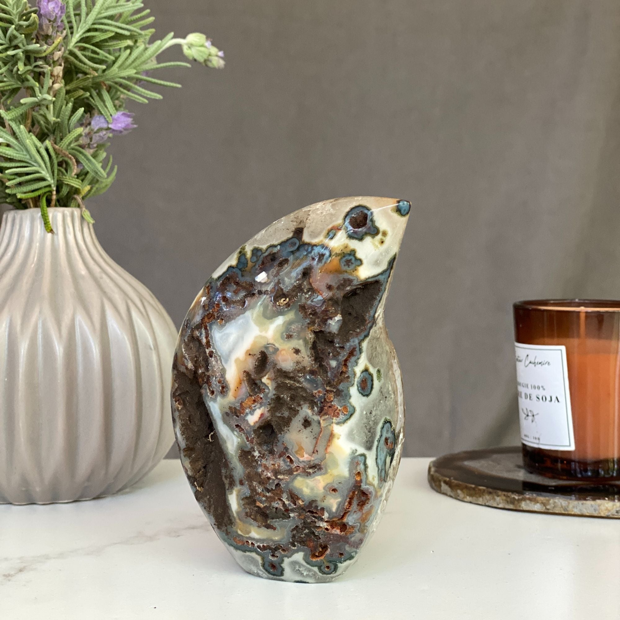 Polished agate flame decor with green, red, and blue natural crystals.