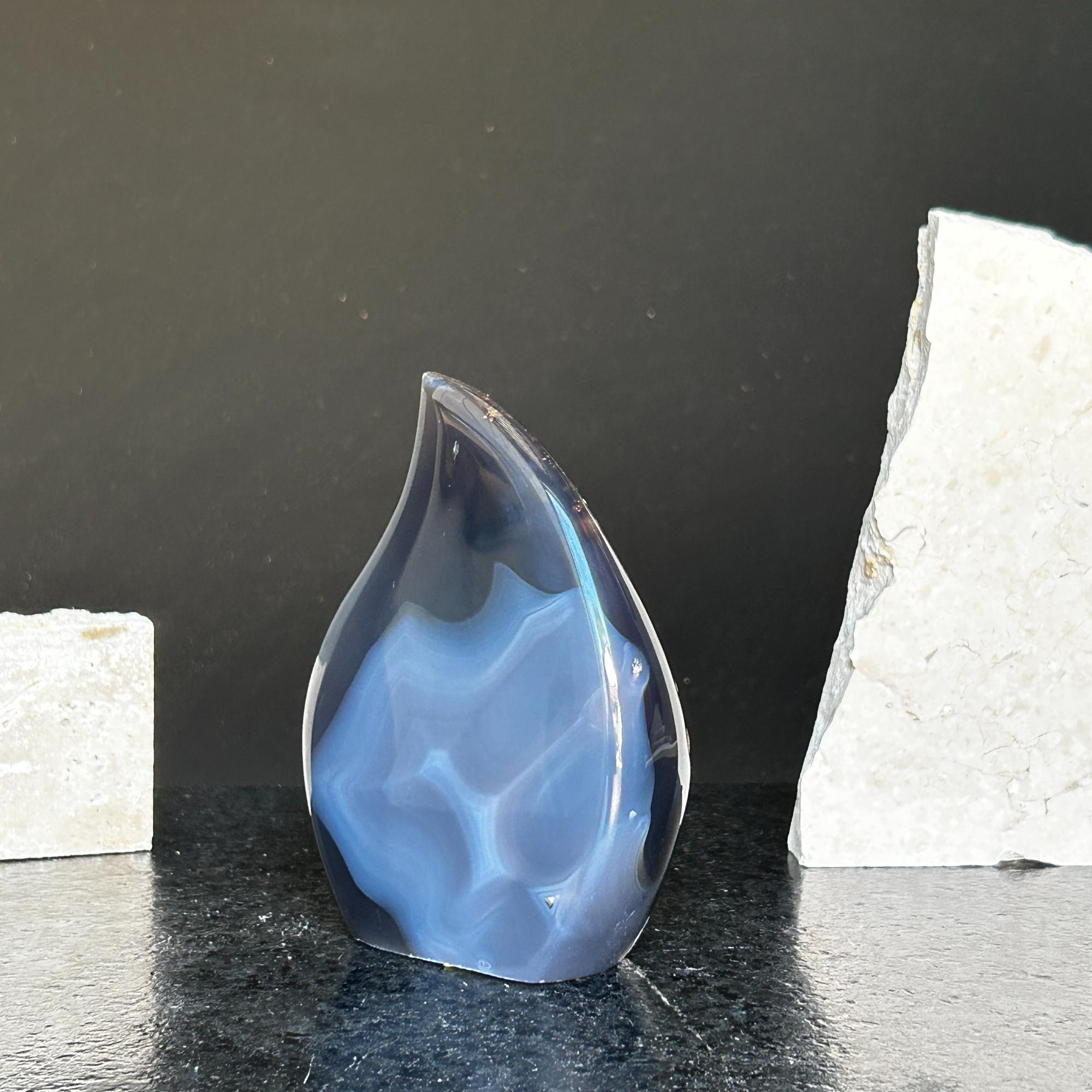 Polished blue agate and quartz flame crystal, 5-inch tall, with white formations, on a dark surface.