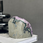 Uruguayan amethyst cave geode with vibrant purple crystals, agate formations, and a raw gray base.