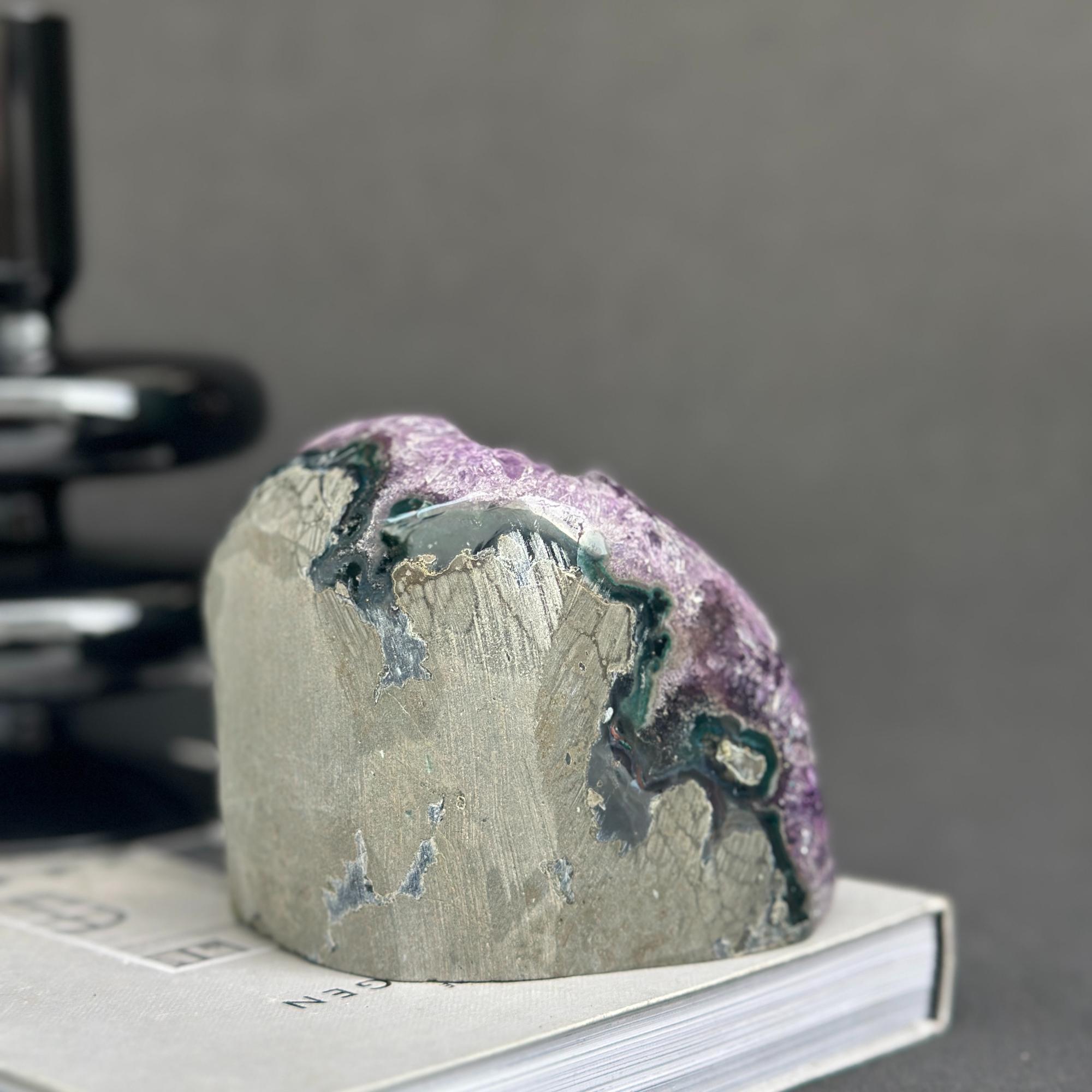 Uruguayan amethyst cave geode with vibrant purple crystals, agate formations, and a raw gray base.
