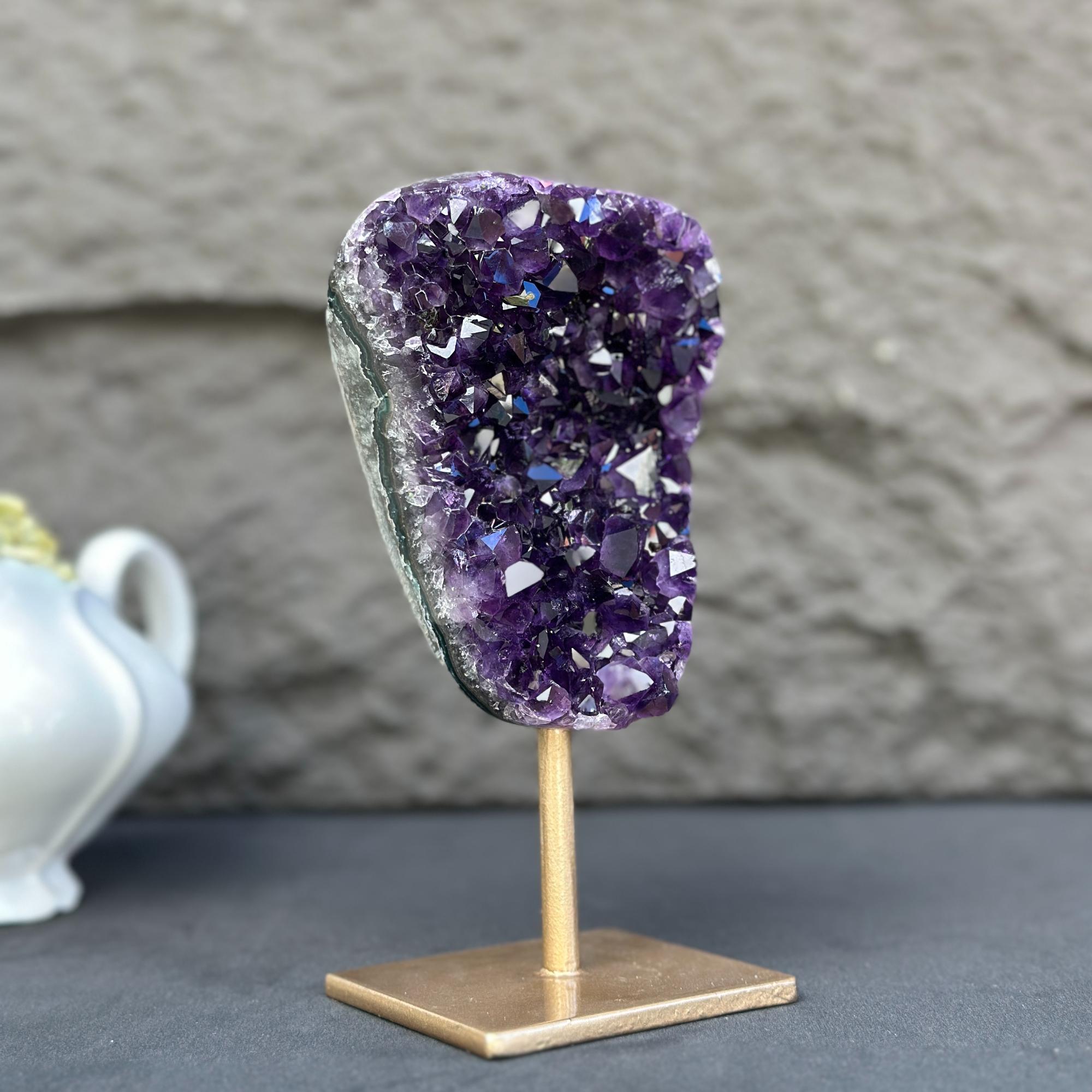 Extra large, natural deep purple amethyst crystal geode on a gold metal stand.