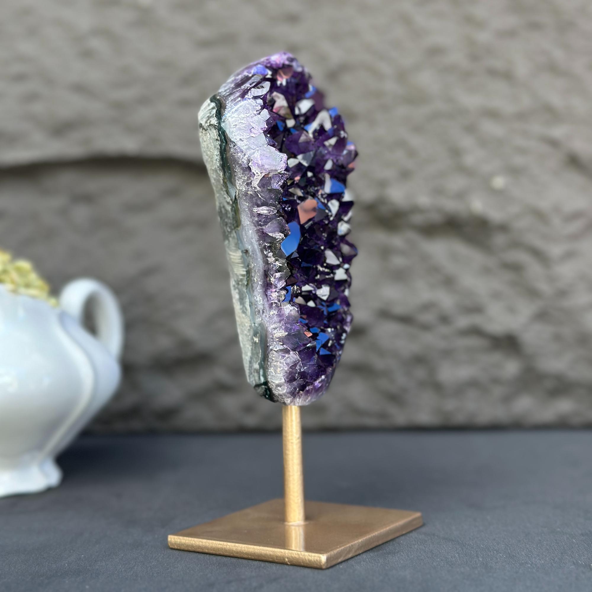Extra large, natural purple amethyst crystal geode on a sleek gold metal stand.