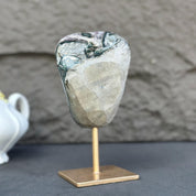 Extra large amethyst crystal with natural purple and green hues on a gold metal stand.