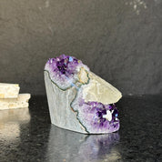 Rare amethyst cathedral with deep purple crystals, polished edges, and a natural stone base.