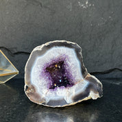 Extra large Uruguayan amethyst geode with deep purple crystals and white agate edges.