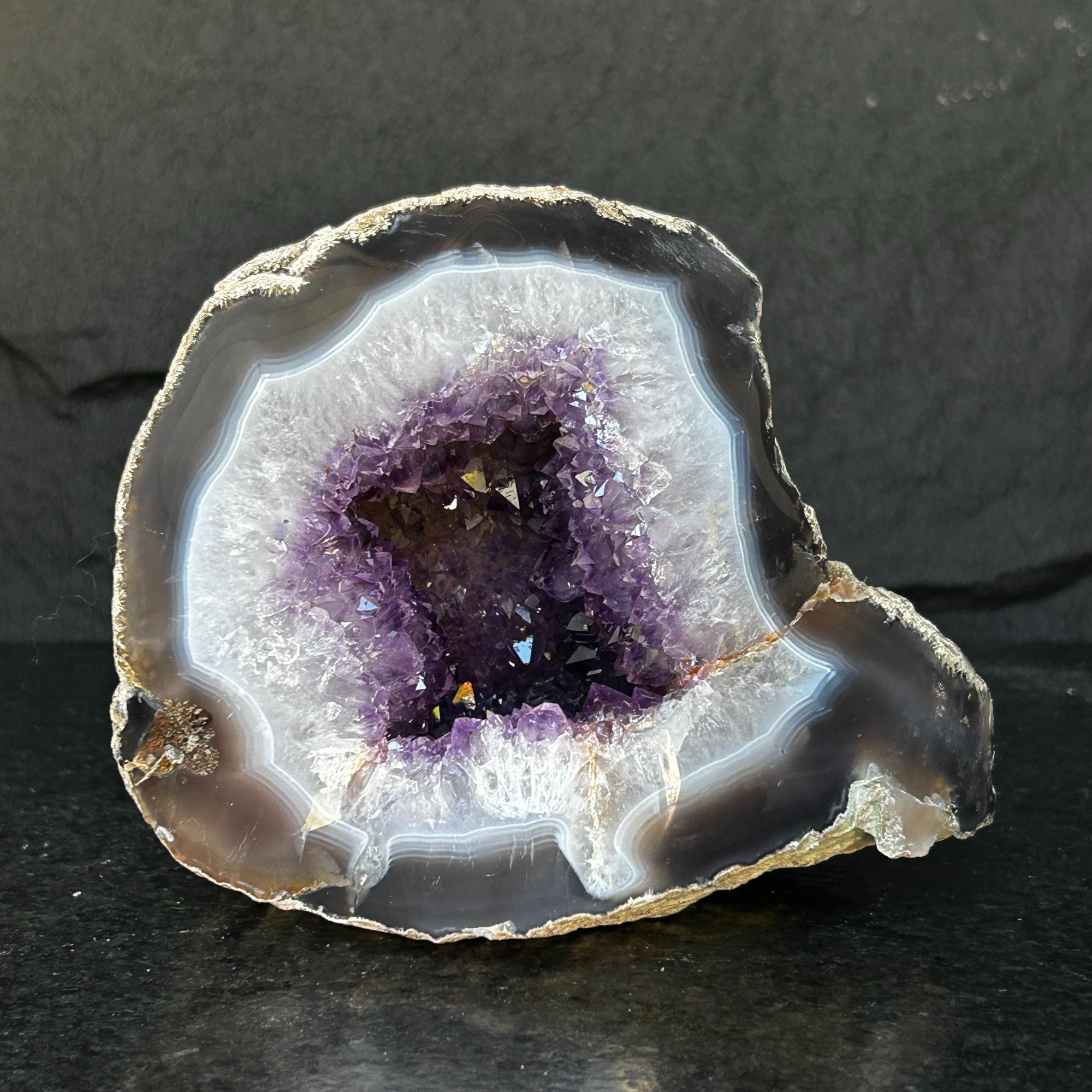 Extra large Uruguayan amethyst geode with deep purple crystals and white agate edges.