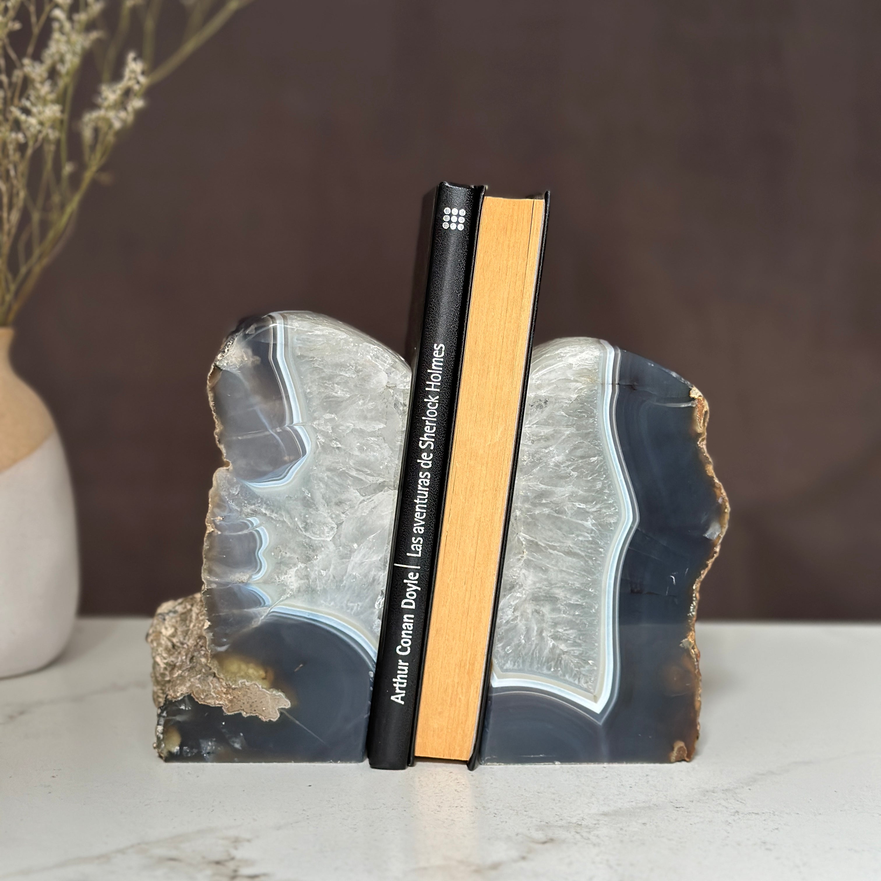 Large amethyst and agate geode bookends with deep purple crystals and natural rough edges, holding two books.