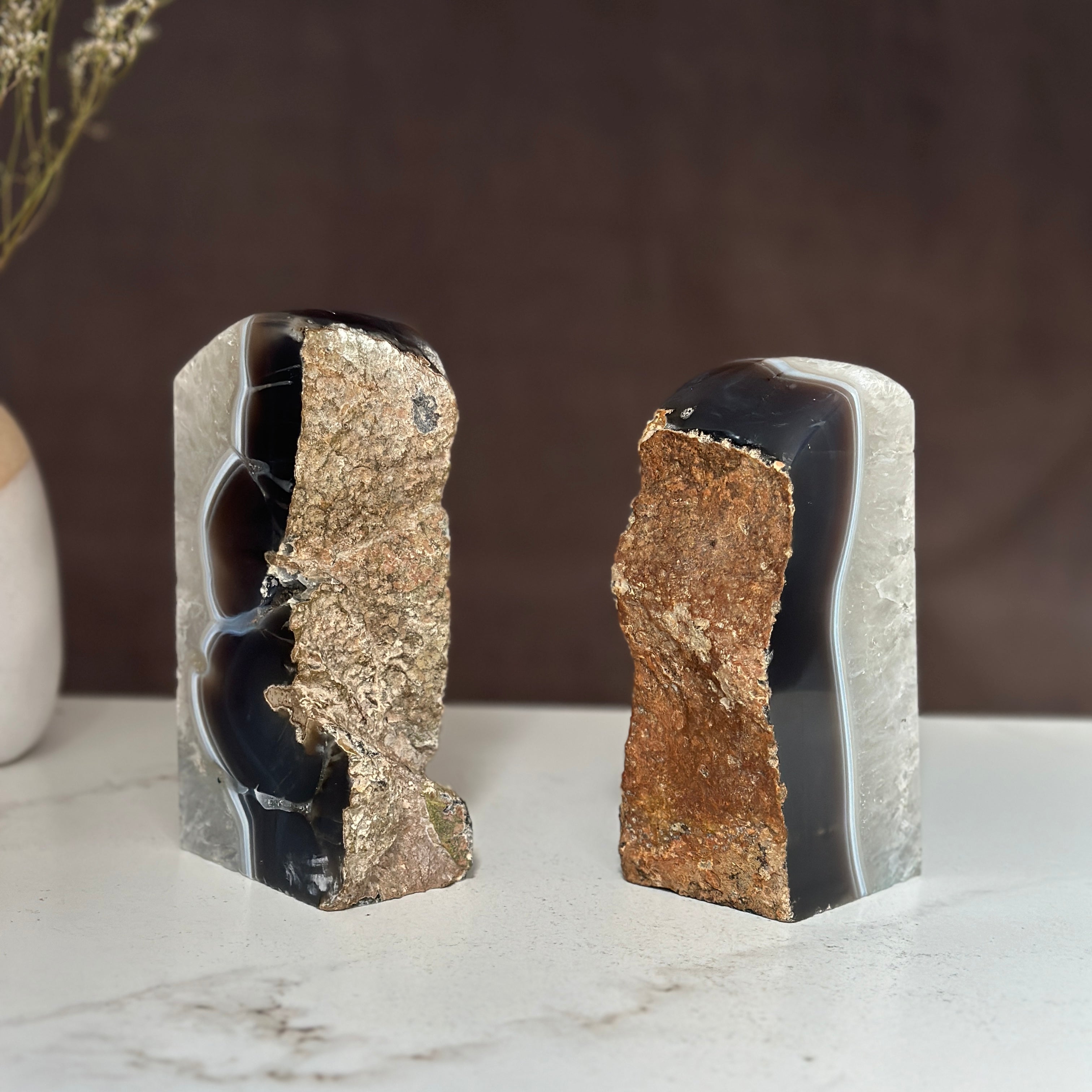 Pair of natural amethyst and agate geode bookends with deep purple crystals and rough brown exteriors.