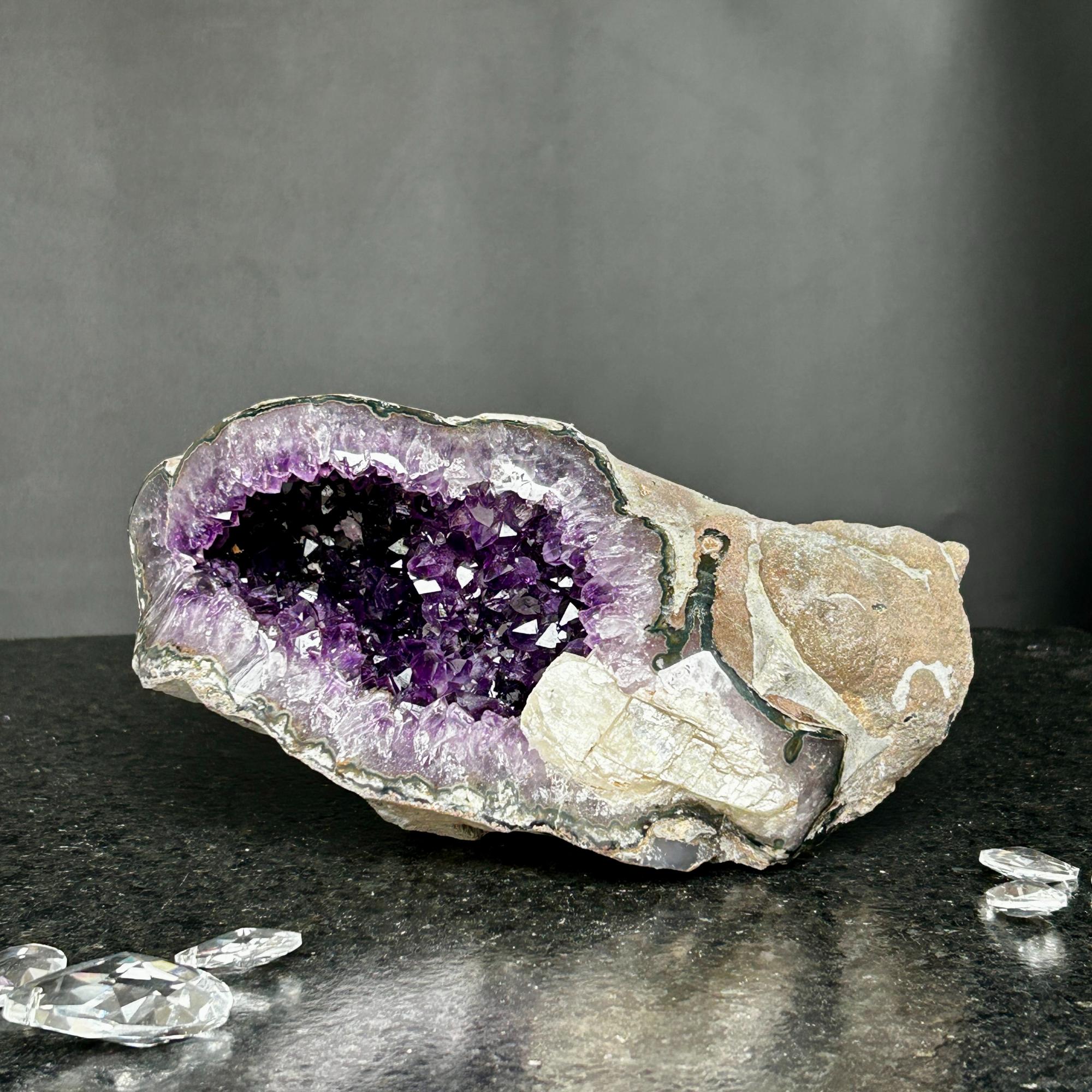 Large Uruguayan amethyst geode with deep purple crystals and a natural rock exterior.