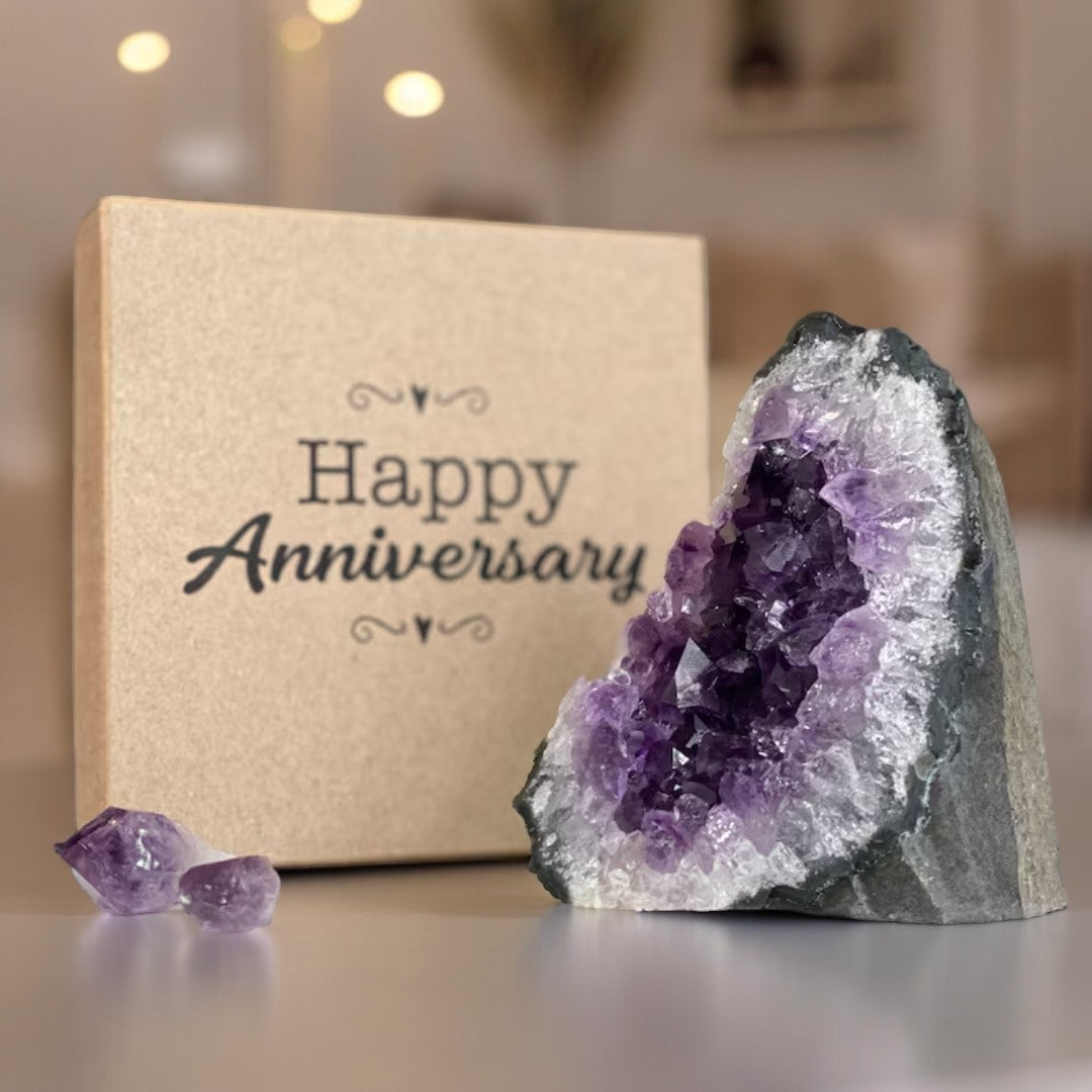Stunning purple amethyst geode, two raw crystals, and a brown "Happy Anniversary" premium gift box.