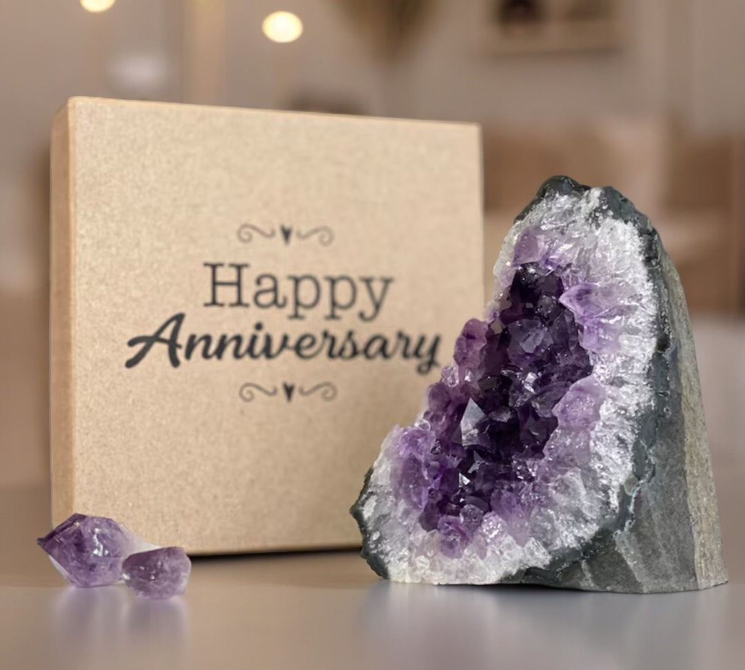 Stunning purple amethyst geode, two raw crystals, and a brown "Happy Anniversary" premium gift box.