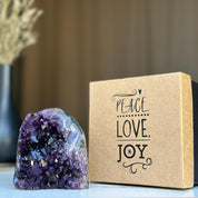 Amethyst anniversary gift box with a sparkling purple geode and "PEACE LOVE JOY" text.