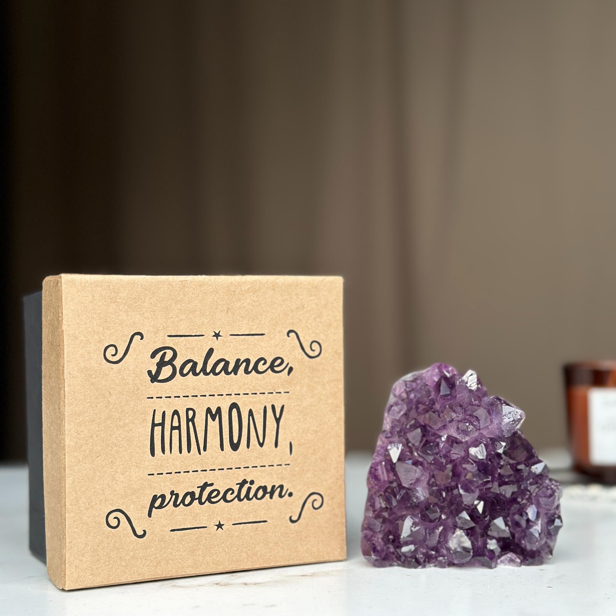 Premium kraft anniversary gift box with inspirational text and a sparkling deep purple amethyst crystal cluster.