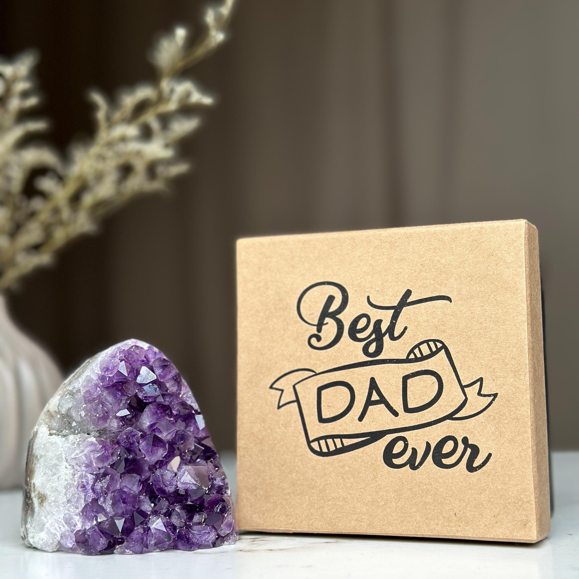 Raw purple amethyst geode next to a brown kraft gift box with 'Best DAD ever' in black script.