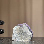 Self-standing Uruguayan amethyst geode with deep purple crystals and natural grey rock base.
