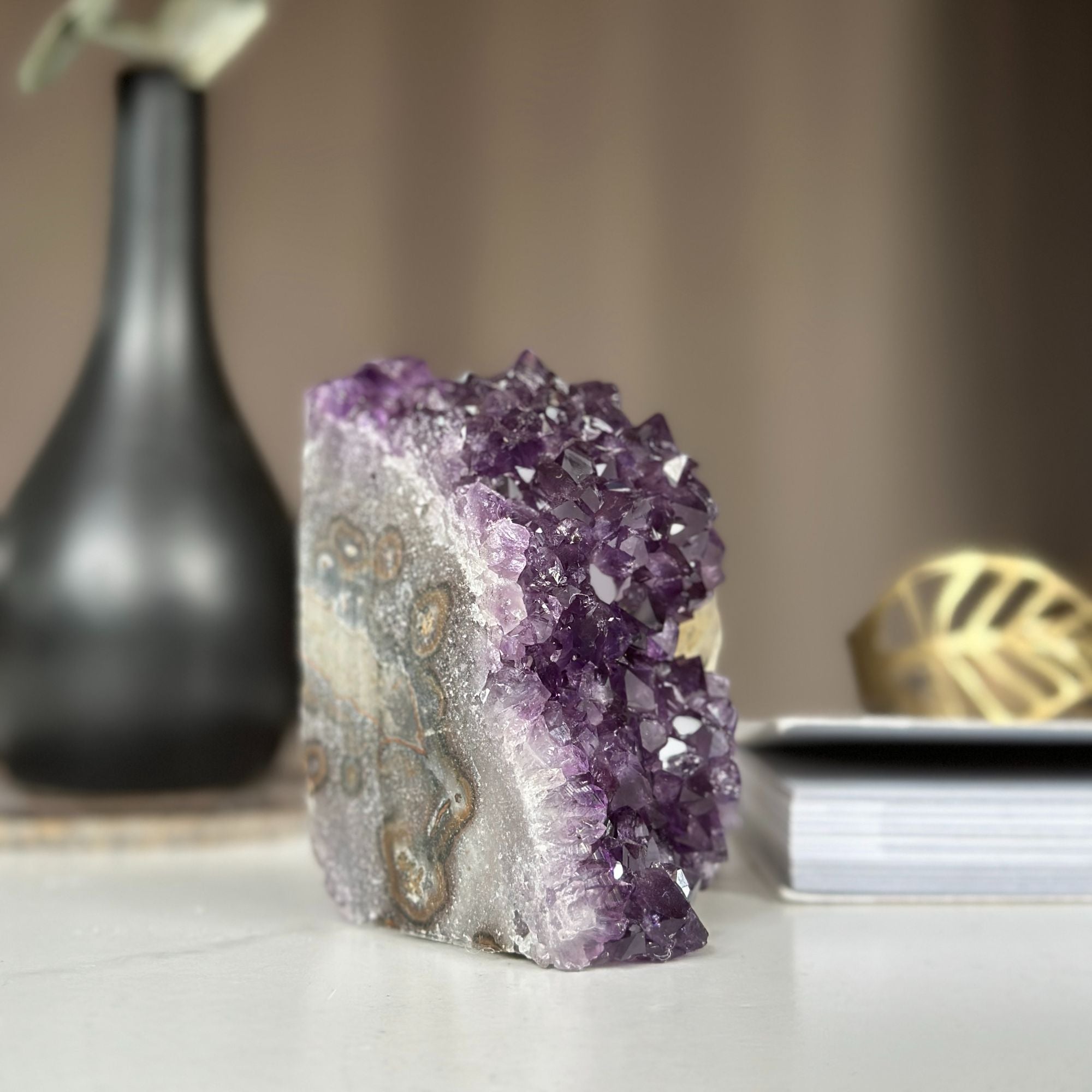 Vibrant purple amethyst cathedral geode, self-standing, with natural grey and brown rock details.
