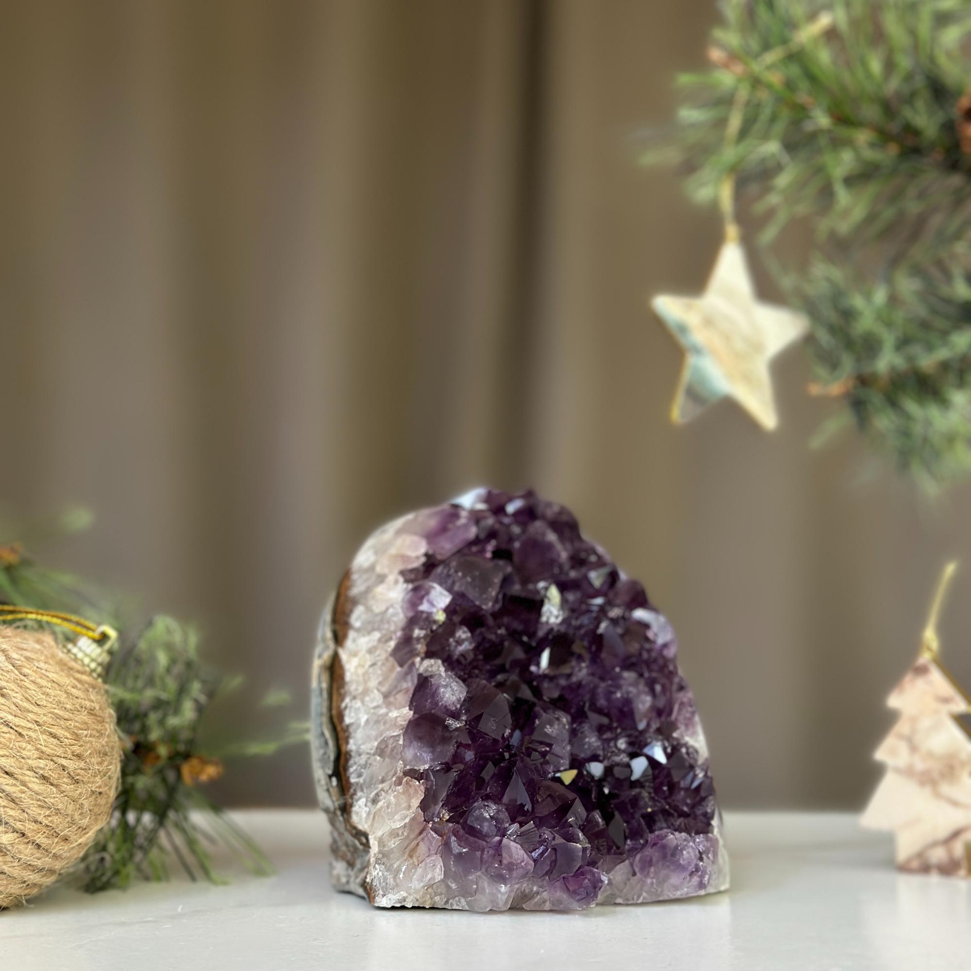 Deep purple Uruguayan amethyst cathedral geode, 3x3 inches, on a white surface with Christmas decor.