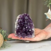 Deep purple Uruguayan amethyst cathedral geode, 3x3 inches, held in a hand.