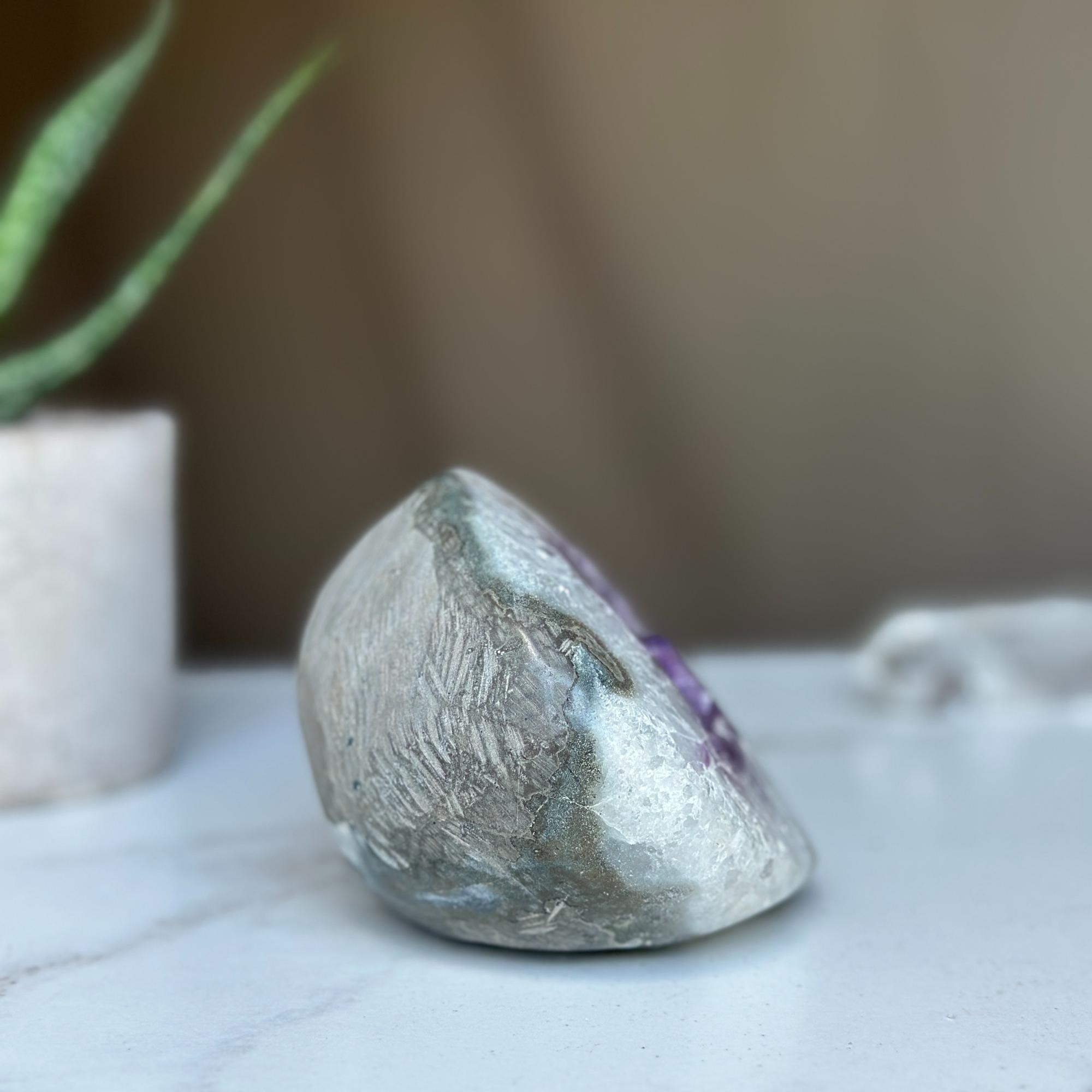 Polished amethyst geode cave with deep purple crystals and gray agate edges.