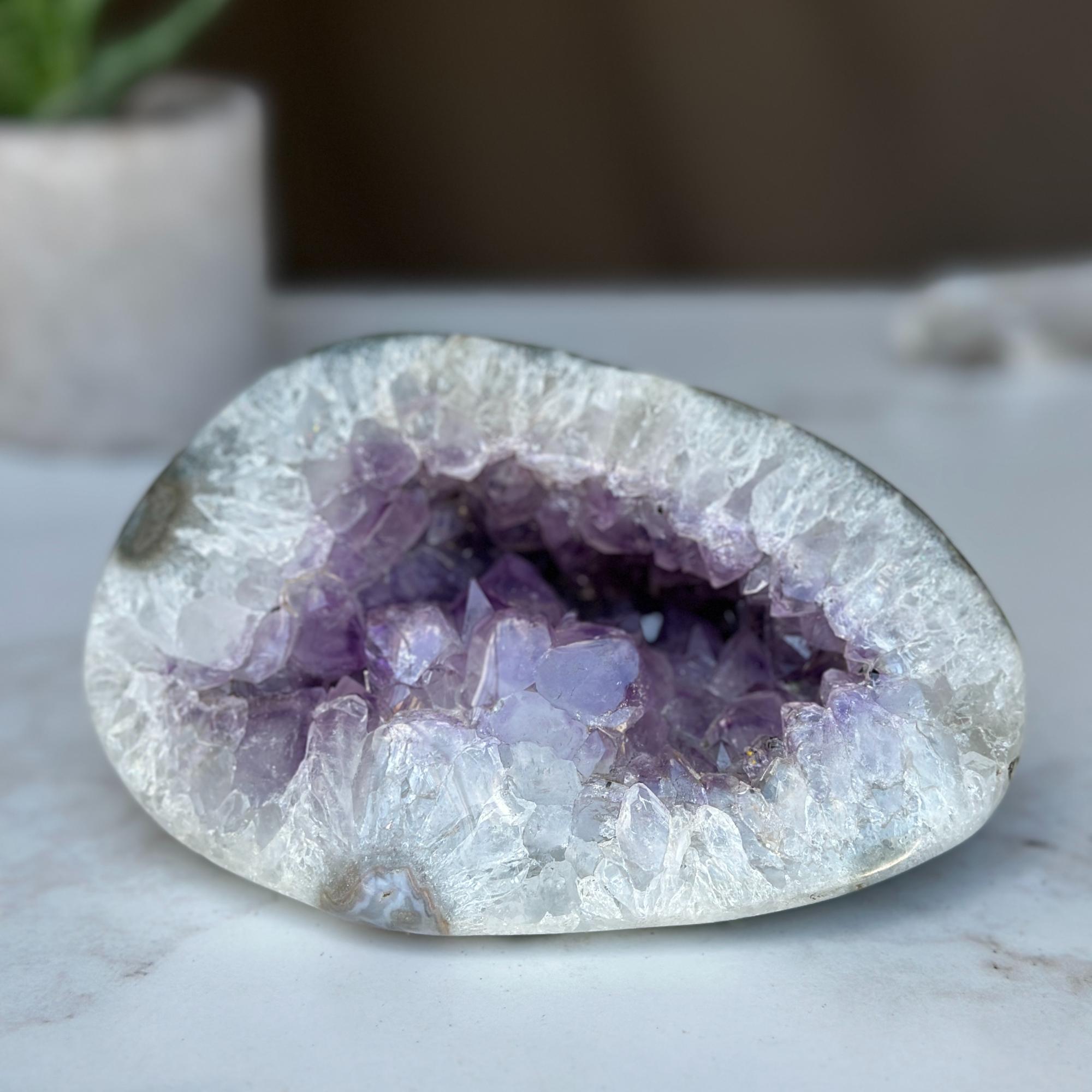 Polished amethyst geode cave with deep purple crystals and white agate edges, 5.5x4 inches.
