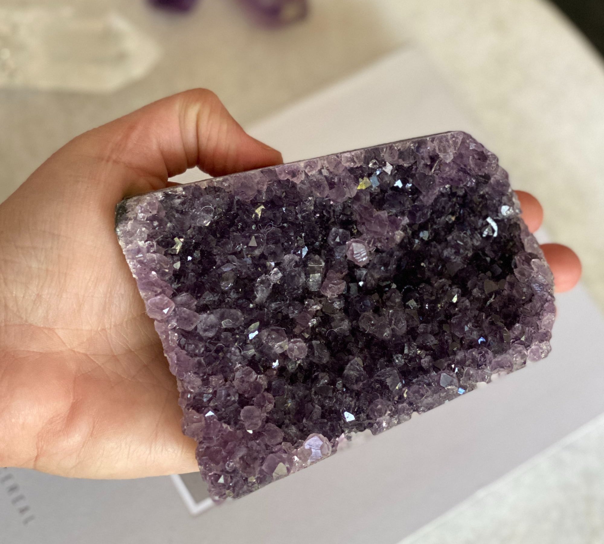 Hand holding a vibrant deep purple amethyst crystal geode cluster, 3x4.3 inches.
