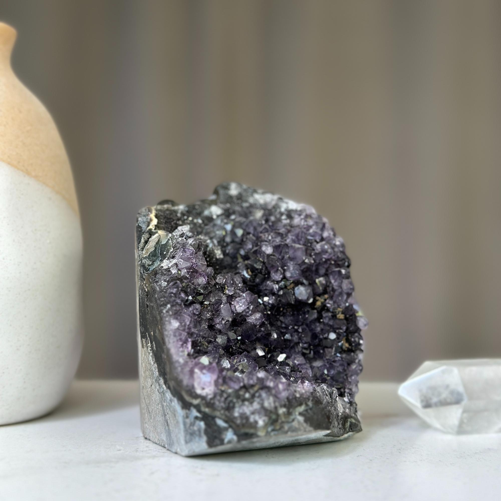 Polished deep purple amethyst cluster geode with sparkling violet crystals and natural agate formations.