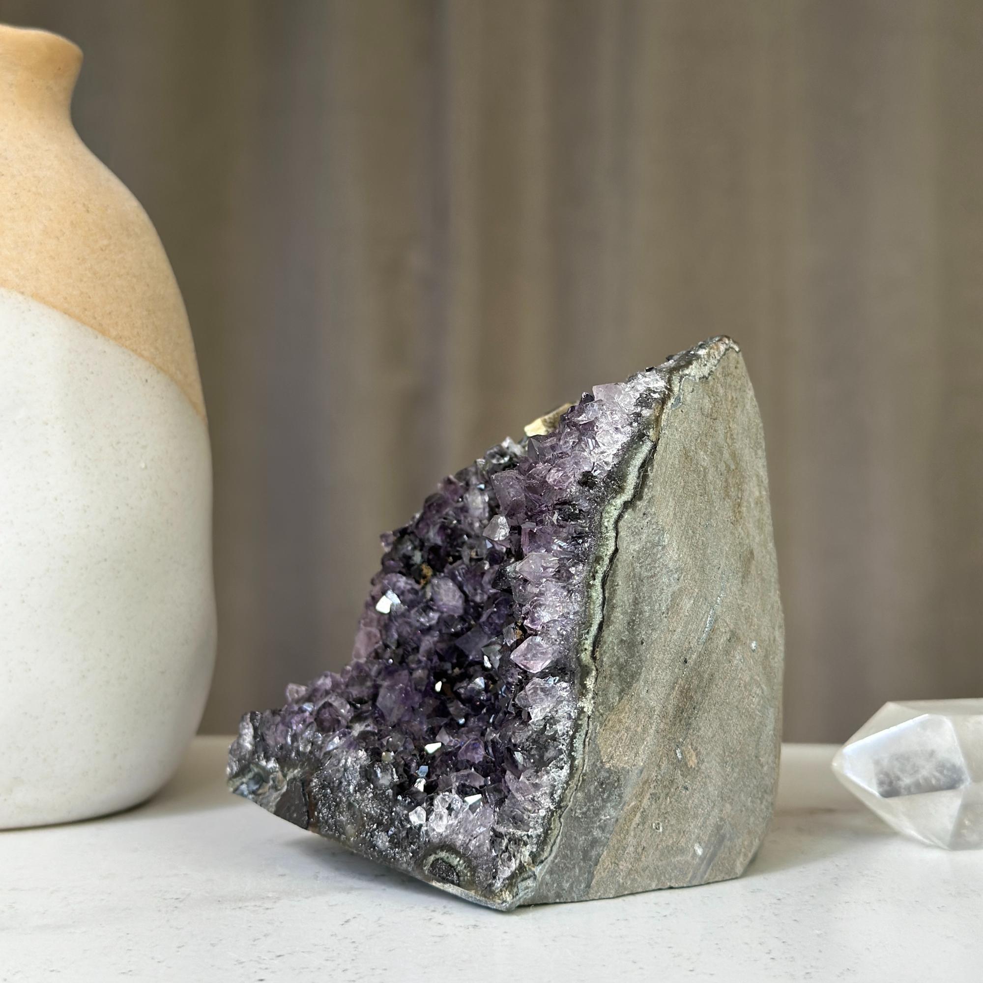 Deep purple amethyst crystal cluster geode with rough grey rock exterior, 4 inches tall.