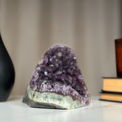 Large, sparkling purple amethyst geode cluster with huge crystals and a light green base.