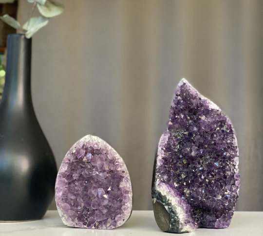 Two natural amethyst flame clusters with sparkling purple druzy and grey agate edges.
