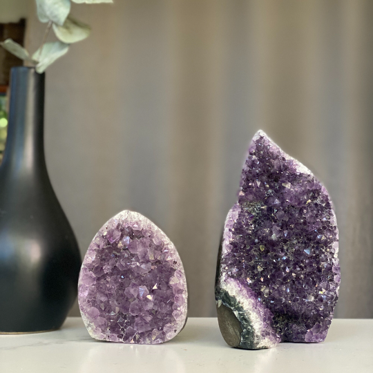 Two natural amethyst flame clusters with sparkling purple druzy and grey agate edges.