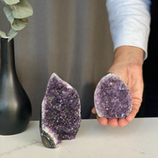 Set of two natural purple druzy amethyst flame clusters, one large standing, one small held, with agate edges.