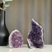 Two natural amethyst flame clusters with deep purple druzy crystals and polished agate edges.