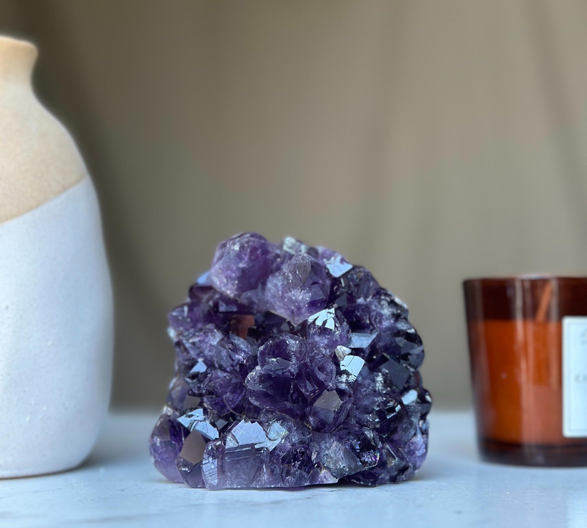 Large vibrant deep purple amethyst geode crystal cluster with sparkling facets.