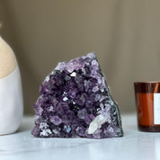 Large deep purple amethyst geode crystal cluster with sparkling facets and natural agate edges.