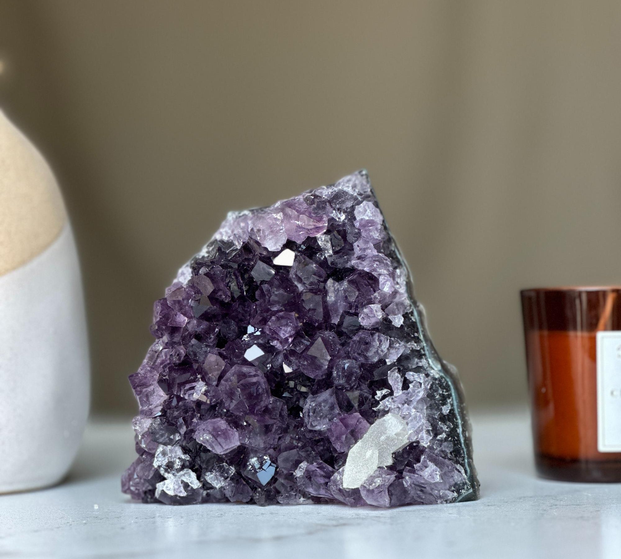 Large deep purple amethyst geode crystal cluster with sparkling facets and natural agate edges.