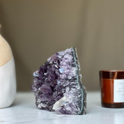Deep purple amethyst geode crystal cluster with sparkling facets and natural agate edges.