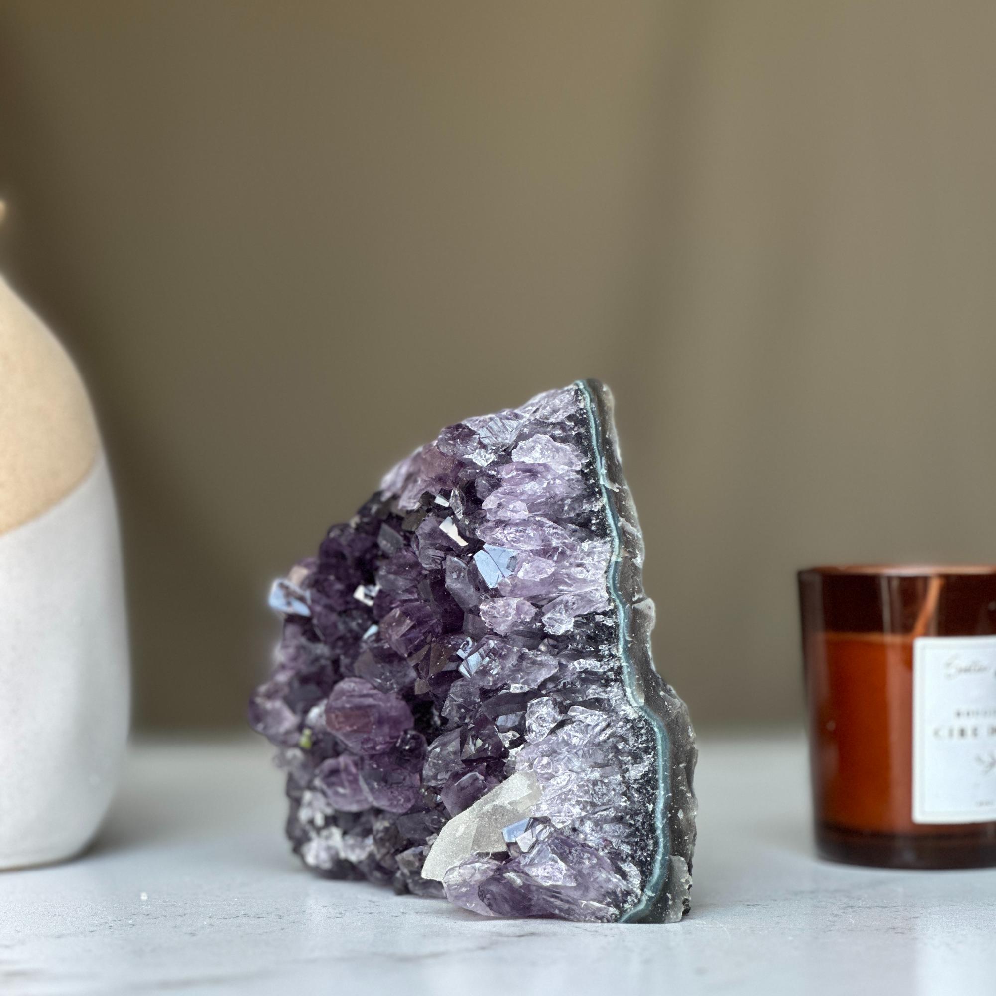 Deep purple amethyst geode crystal cluster with sparkling facets and natural agate edges.