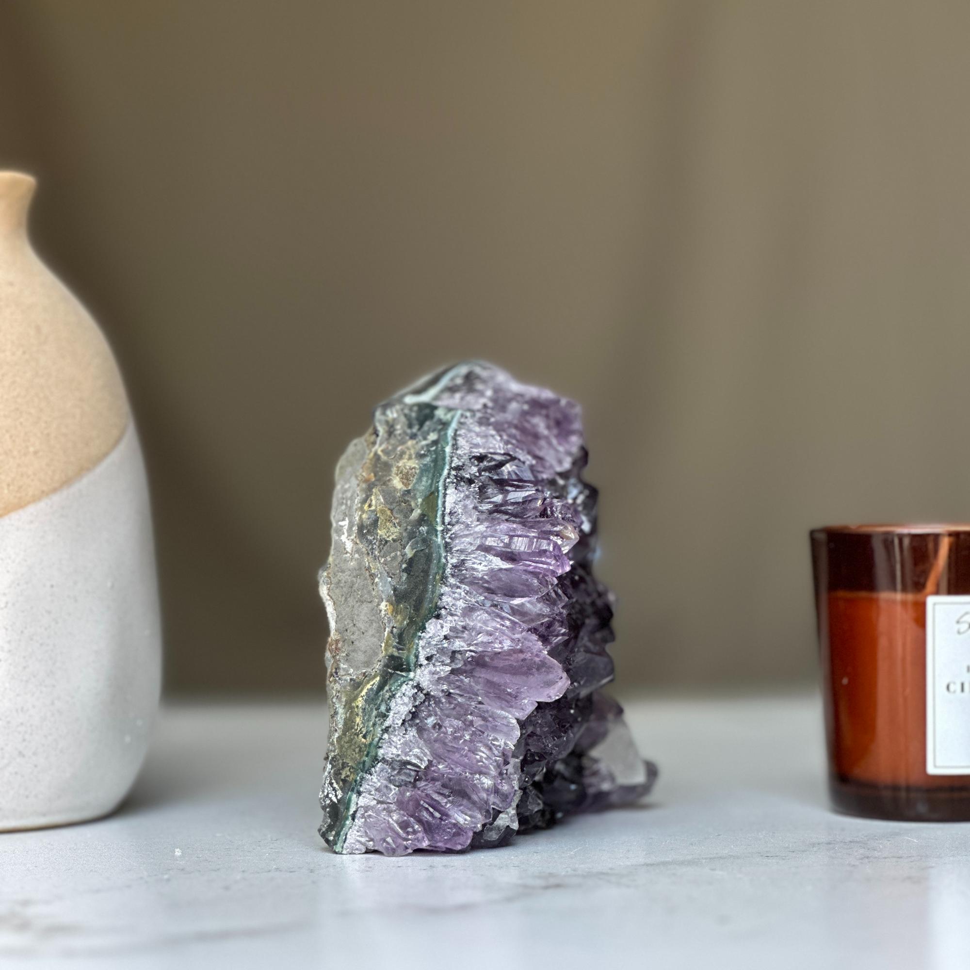 Large deep purple amethyst geode crystal cluster with sparkling crystals and natural agate edges.