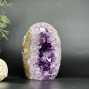 Vibrant deep purple amethyst geode, egg-shaped with sparkling crystal clusters and agate edges.