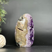 Deep purple amethyst geode, egg-shaped with natural agate edges, standing upright.
