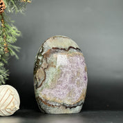 Deep purple Uruguayan amethyst geode, egg-shaped, with natural agate edges and sparkling crystal clusters.