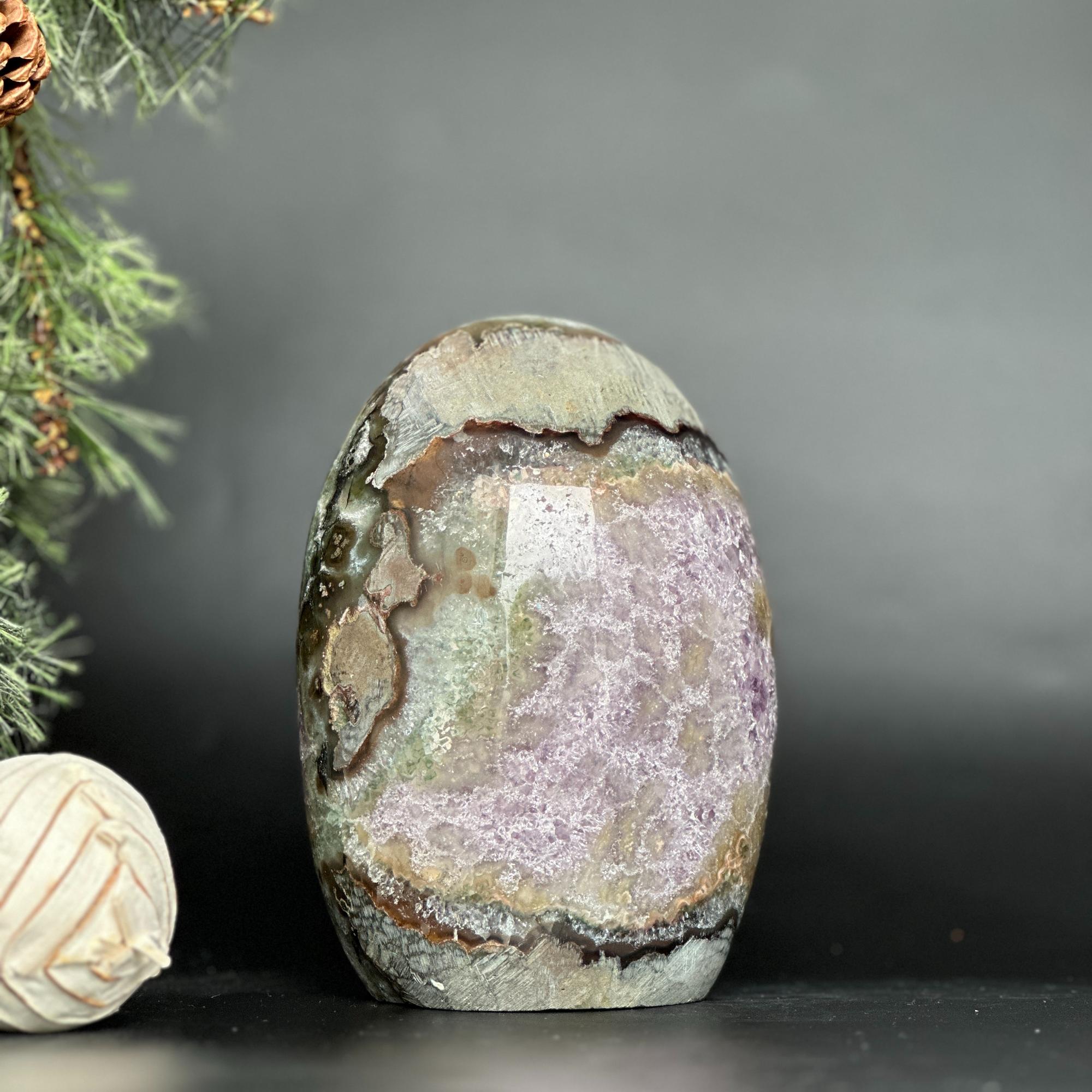 Deep purple Uruguayan amethyst geode, egg-shaped, with natural agate edges and sparkling crystal clusters.