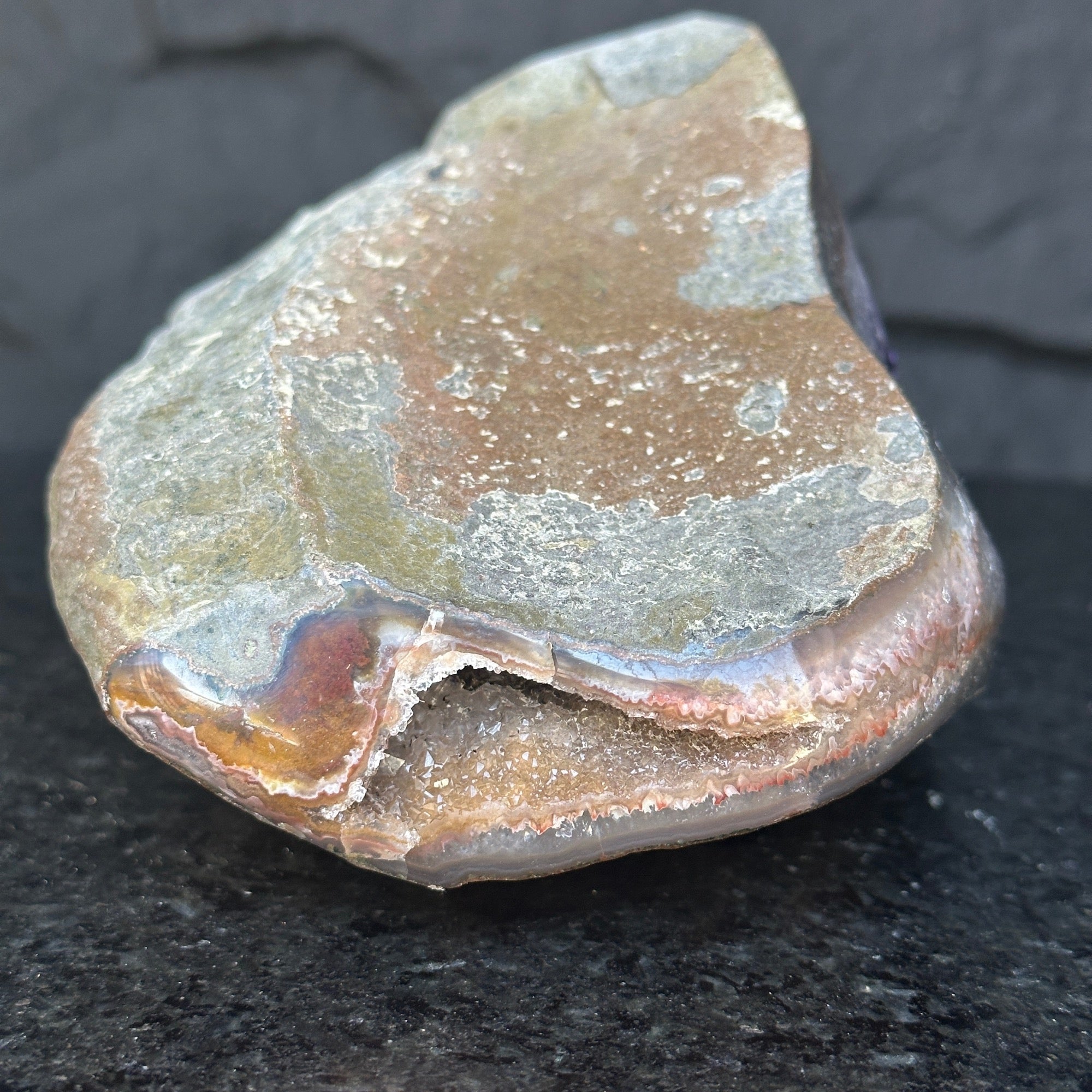 Self-standing Uruguayan amethyst geode, rough earthy exterior, sparkling purple crystal interior.**