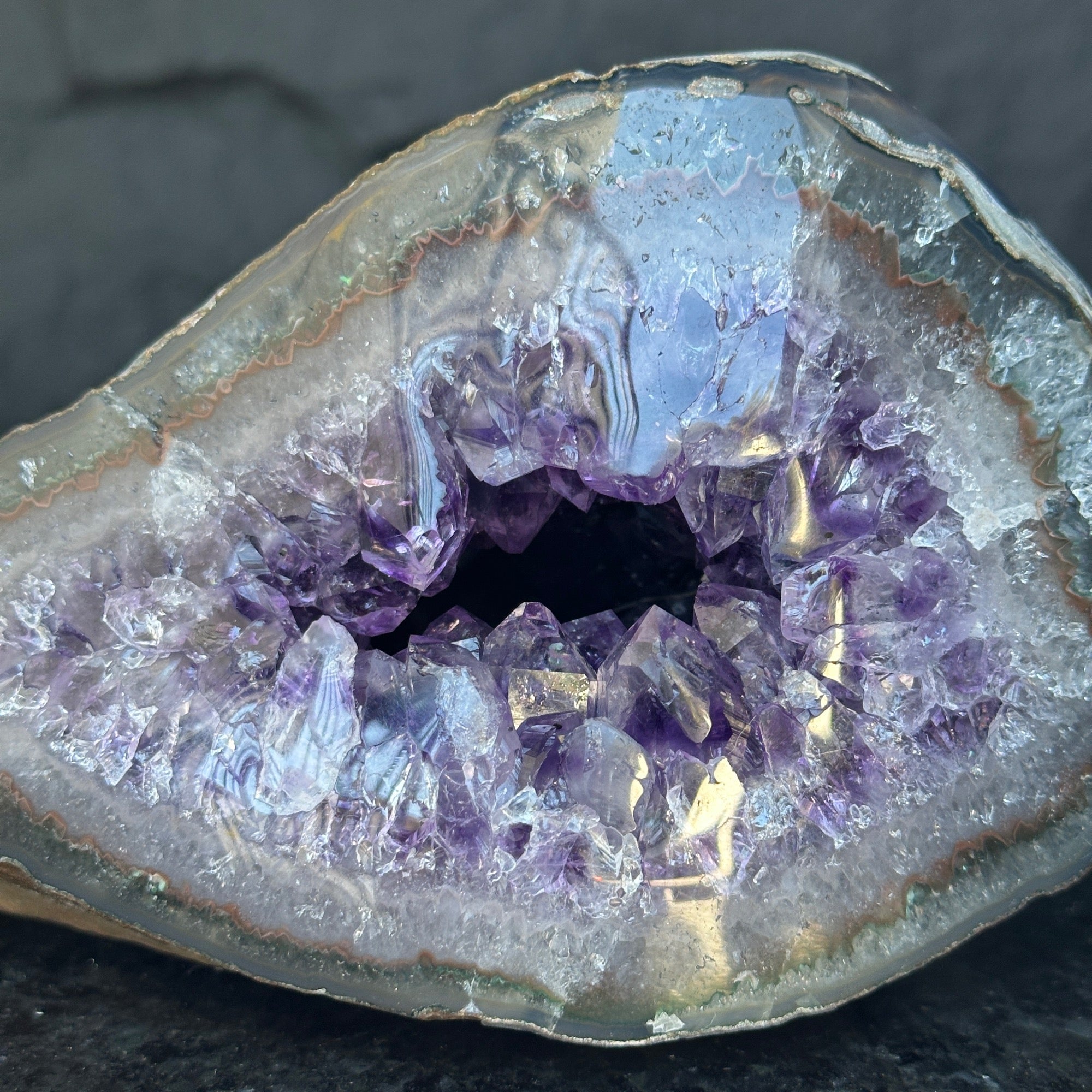 Self-standing Uruguayan amethyst geode, 7x4 inches, with deep purple sparkling crystals and a natural agate rim.