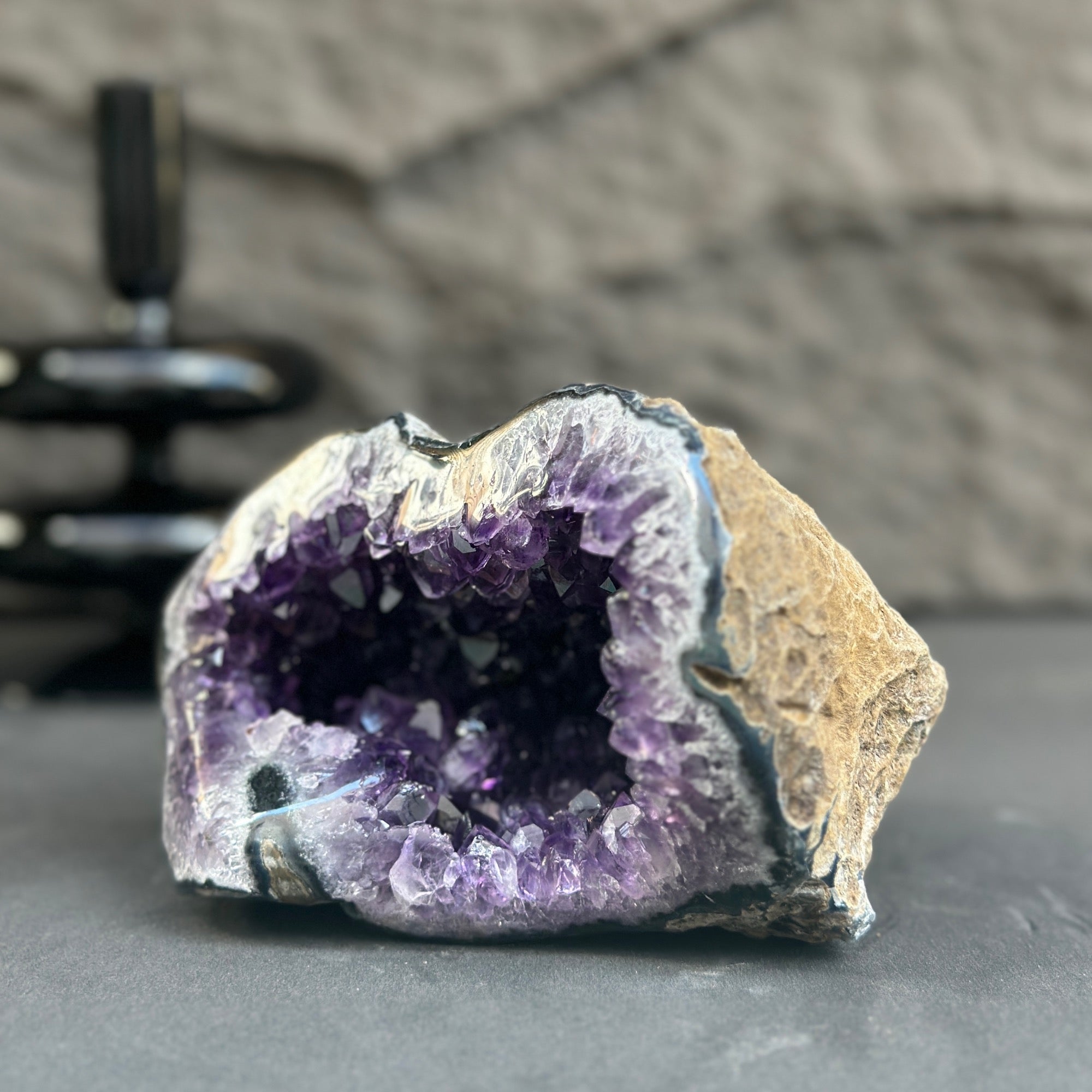 Uruguayan amethyst geode with deep purple crystals and a natural stone exterior.