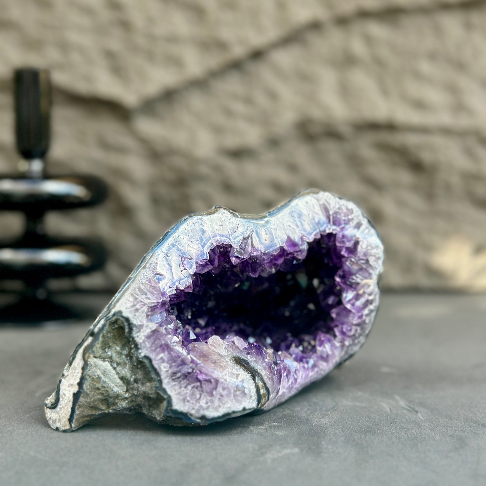 Uruguayan amethyst geode with deep purple crystals and a natural grey exterior.