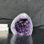 Self-standing Uruguayan amethyst geode with deep purple crystals and gray-green agate edges.