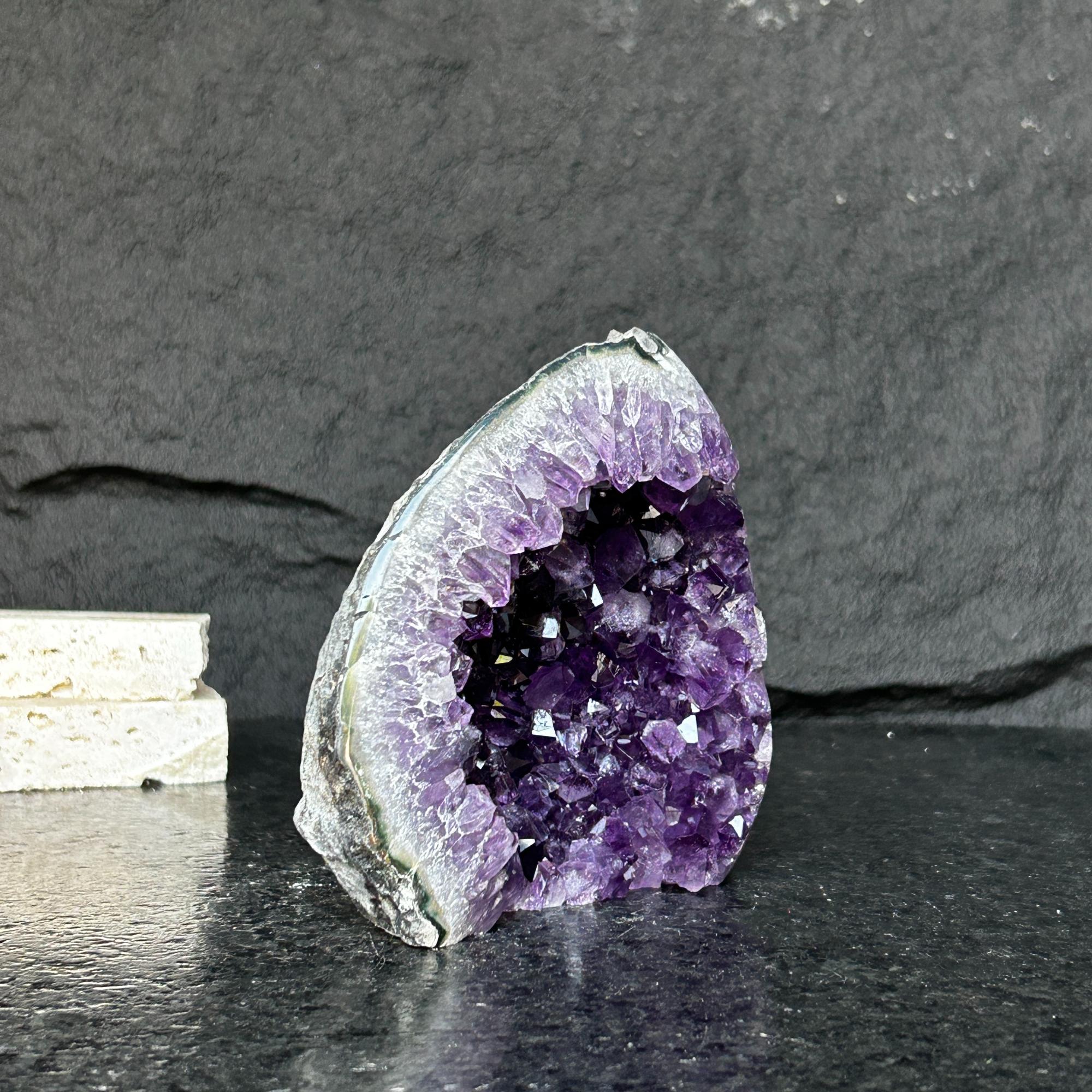 Self-standing Uruguayan amethyst geode with deep purple crystals and gray-green agate edges.