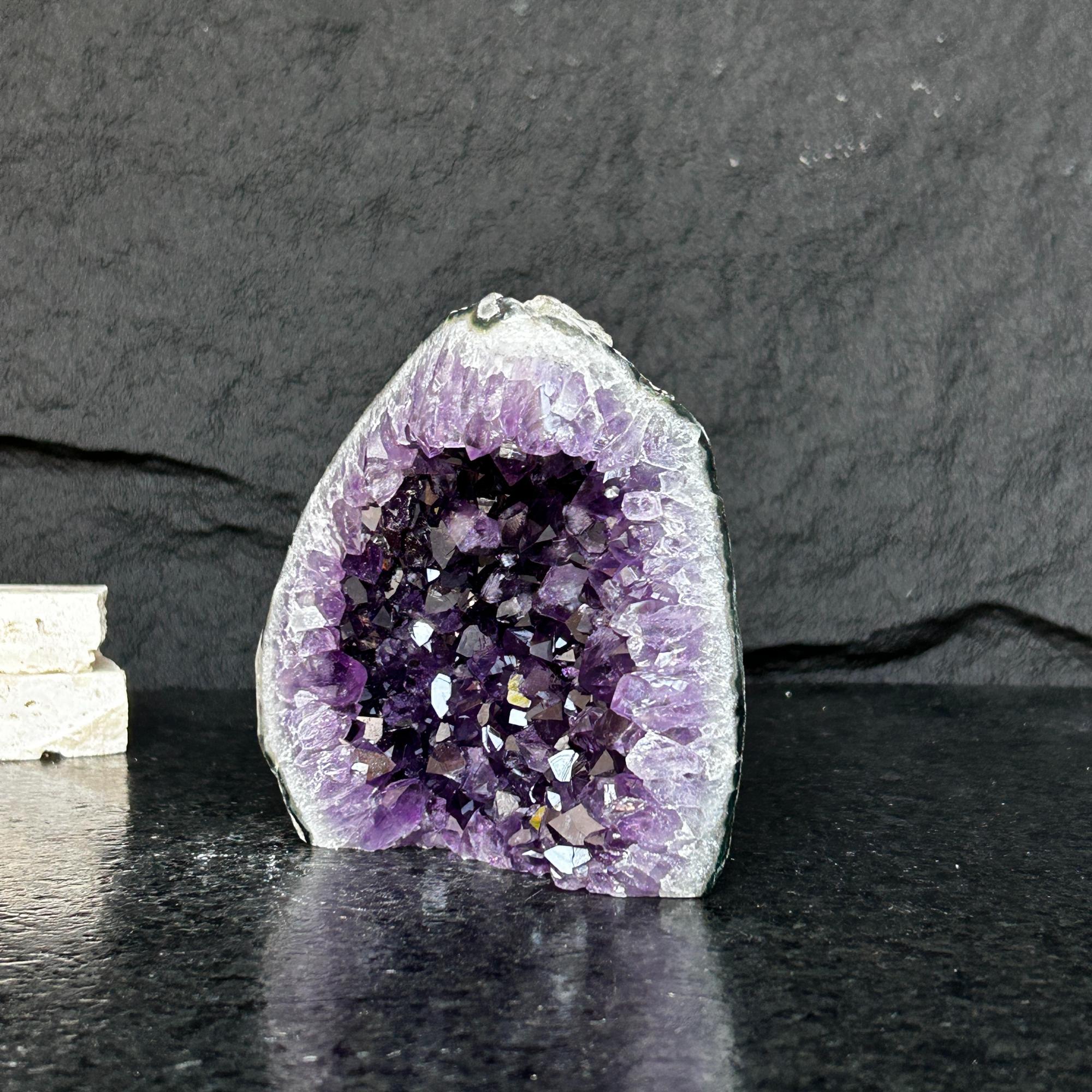 Self-standing Uruguayan amethyst geode with deep purple crystals and gray-green agate edges.