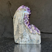 Extra large Uruguayan amethyst geode with deep purple crystals and gray agate formations.